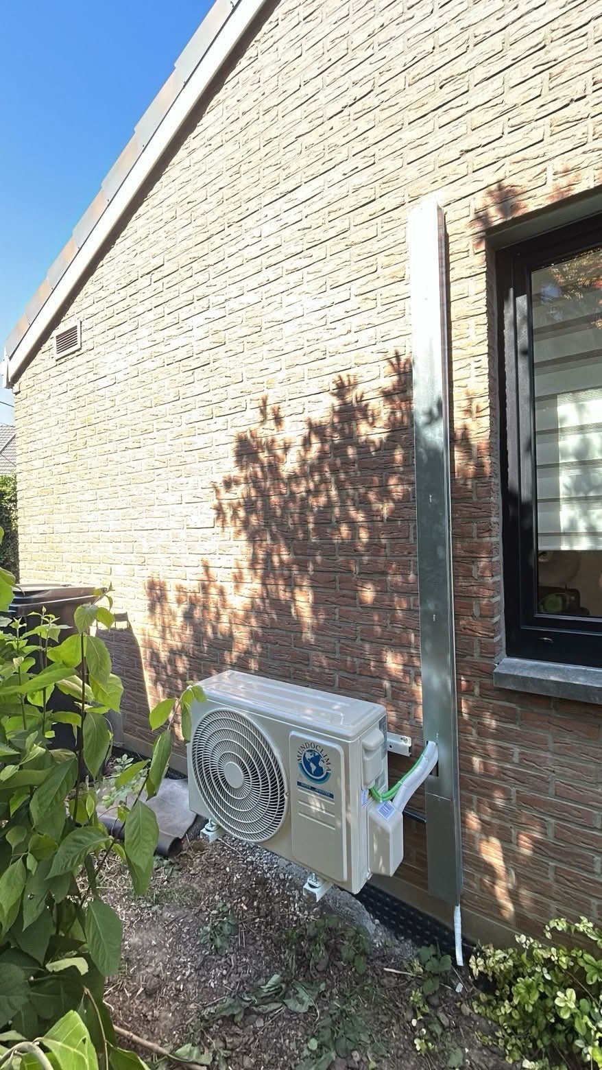 Unité extérieure de climatisation avec habillage vertical sur une maison