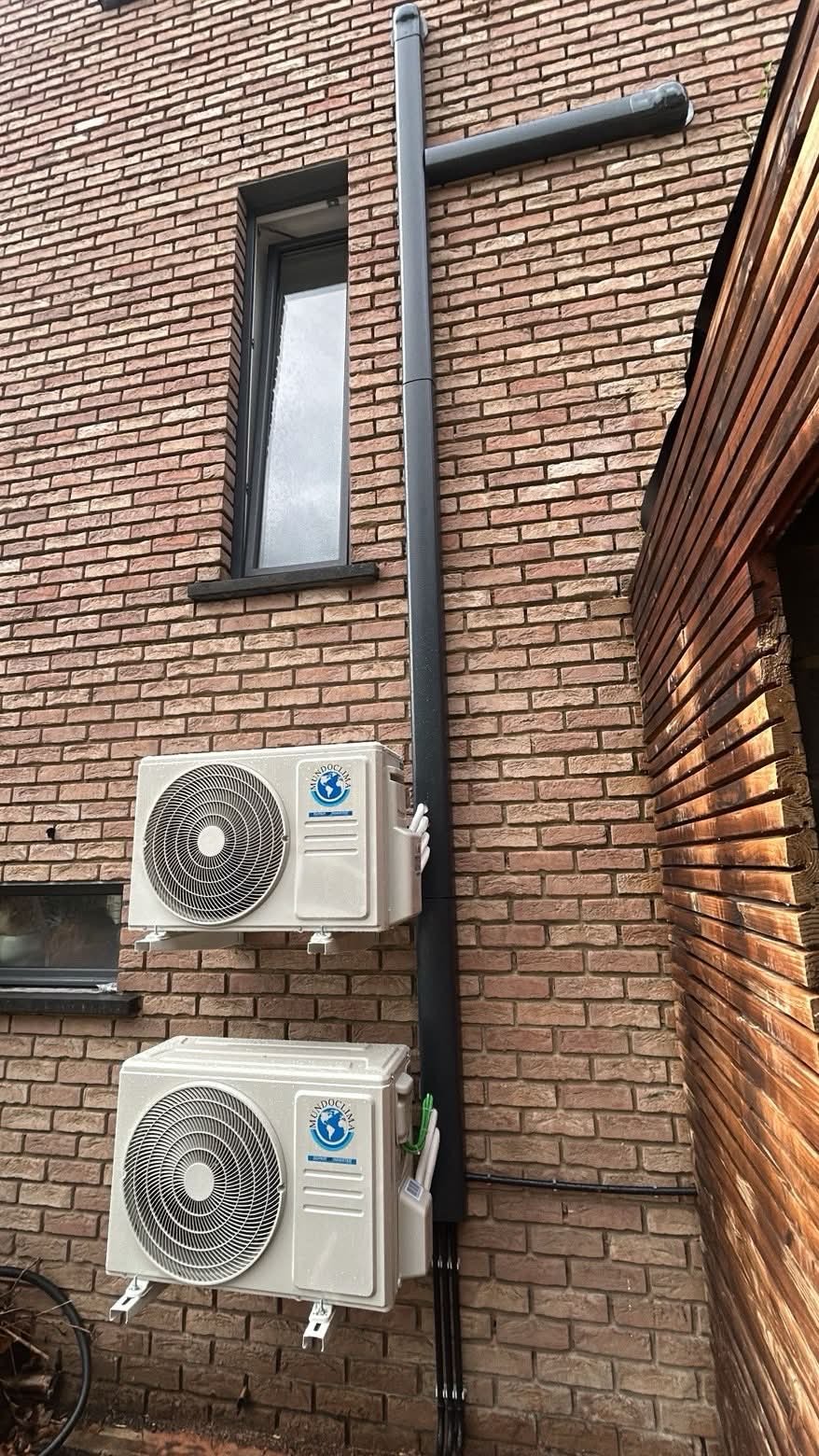 Deux unités extérieures de climatisation installées sur une façade en briques